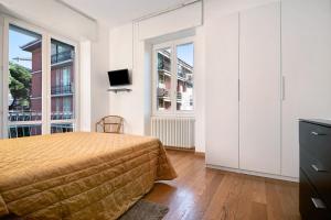 Un dormitorio con una cama y un televisor y ventanas. en Casa mare Levanto 1, en Levanto