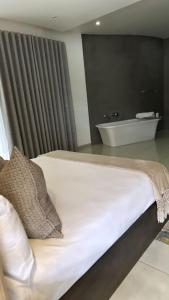 Schlafzimmer mit einem Bett und einer Badewanne in der Unterkunft Letaba Boutique Hotel and Spa in Giyani