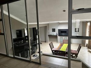 a living room with a table and a dining room at Korsmans Delights - Large House in Benoni