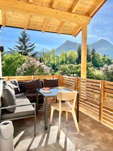 a patio with a table and chairs on a deck at Fuxbau Waldlounge in Ruhpolding