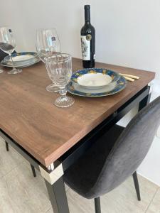 a wooden table with glasses and a bottle of wine at Loft Central in Passo Fundo