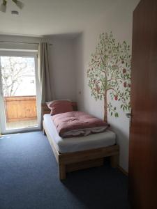 - une chambre avec un lit orné d'une fresque murale sur les arbres dans l'établissement Haus Bergliebe - Breitenbergblick, à Pfronten