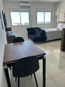 a living room with a bed and a table and chairs at Loft Central in Passo Fundo