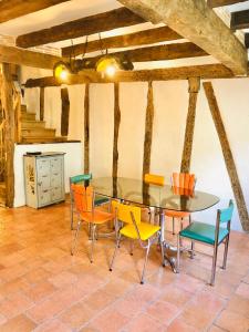 jadalnia ze szklanym stołem i krzesłami w obiekcie Maison à colombage garage bureau centre village w mieście Francescas