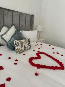 ein Bett mit roten Rosenblättern drauf in der Unterkunft Letaba Boutique Hotel and Spa in Giyani