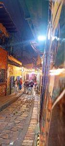 um beco com pessoas andando por uma rua à noite em Casa bella vista em Bogotá