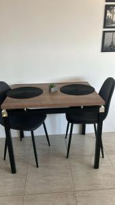 a wooden table with two black chairs around it at Loft Central in Passo Fundo