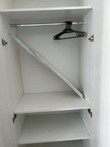 a white shelf in a closet with a light on it at Loft Central in Passo Fundo