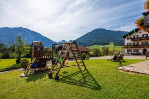 um parque infantil num quintal com montanhas ao fundo em Brandstätter Hof em Ruhpolding