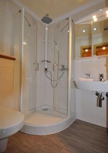 uma casa de banho com um chuveiro e um lavatório. em Brandstätter Hof em Ruhpolding
