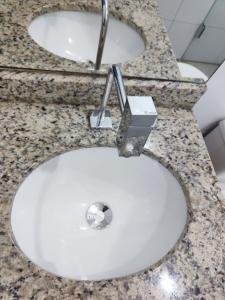 a white sink with a faucet in a bathroom at Loft Central in Passo Fundo