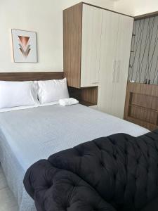 a bedroom with a large bed with a white bedspread at Loft Central in Passo Fundo