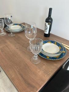 a wooden table with glasses and a bottle of wine at Loft Central in Passo Fundo