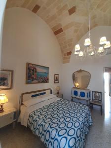 Un dormitorio con una cama azul y blanca y una lámpara de araña. en LaVí - Splendido appartamento sul mare, en Nardò