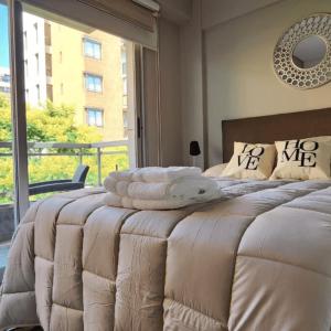 a bedroom with a large bed with a large window at STUDIO MODERNO EN PUERTO MADERO FRENTE AL HOTEL MADERO in Buenos Aires