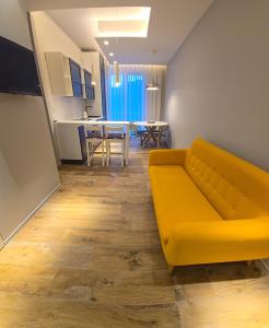 un soggiorno con divano giallo e una cucina di Case Vacanze 106 Maison De Charme a Giovinazzo