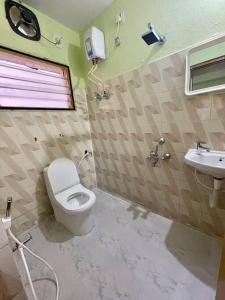 a bathroom with a toilet and a sink at Beautiful 2bhk centrally located with free parking in Hyderabad