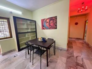 a dining room with a table and chairs and a painting at Beautiful 2bhk centrally located with free parking in Hyderabad