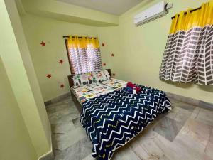 a bedroom with a bed with a black and white comforter at Beautiful 2bhk centrally located with free parking in Hyderabad