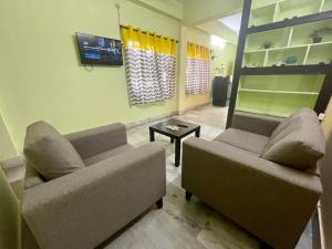 a living room with two couches and a table at Beautiful 2bhk centrally located with free parking in Hyderabad