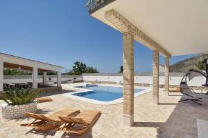 un patio con piscina, sedie e padiglione. di Apartments with private pool a Trogir