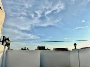een uitzicht op de skyline van de stad vanaf een wit hek bij Stargazing tent in Balcony at EKG House Rental in Manilla
