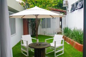 薩爾瓦多的住宿－pousada da sarafina ltda，一张带两把椅子的木桌和一把伞