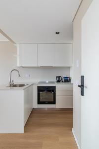 a kitchen with white cabinets and a sink at InSoho by iPPA in Buenos Aires