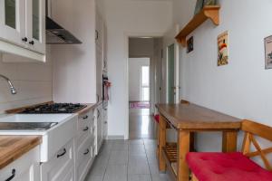 Una cocina con gabinetes blancos y una mesa de madera. en Milan Panoramic Views, Central Location, en Milán