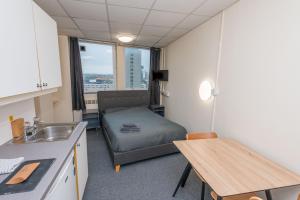 a small room with a bed and a table at Opal Villas standard apartment 4 in Plymouth