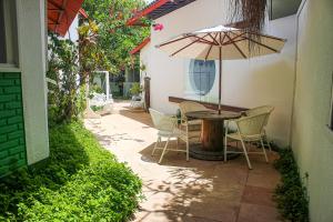 a patio with a table and chairs and an umbrella at pousada da sarafina ltda in Salvador