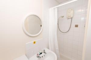 Un baño blanco con lavabo y espejo. en Standard En-suite Apartment 4, en Plymouth