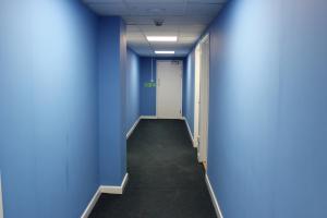 un pasillo vacío en un edificio de oficinas con paredes azules en Standard En-suite Apartment 4, en Plymouth