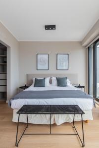 a bedroom with a large bed with two pictures on the wall at InSoho by iPPA in Buenos Aires