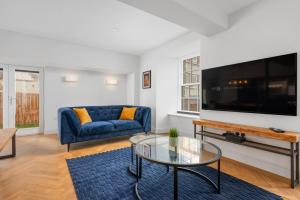 a living room with a blue couch and a tv at 316 Reids Corner - by StayDunfermline in Dunfermline