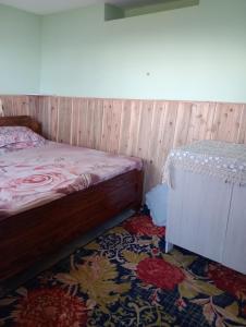 a bedroom with a bed and a rug at Diksha Homestay in Darjeeling