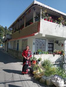 a woman standing in front of a building at Diksha Homestay in Darjeeling