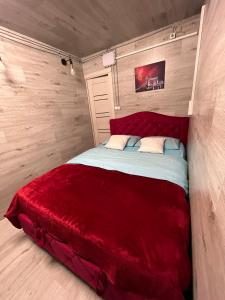 een slaapkamer met een rood bed in een kamer bij Мини отель in Chişinău