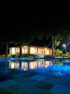 a building at night with a swimming pool at CABAÑA TAYRONACA in Calabazo