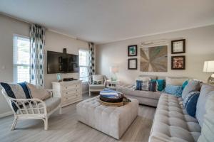 a living room with a couch and a tv at Relax Just Steps to the Soft White Sandy Beach, Heated Pool in Holmes Beach