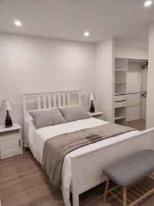 1 dormitorio blanco con 1 cama grande y 1 silla en Loft Praza do Conde, en Puentedeume