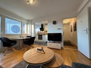 ein Wohnzimmer mit einem Tisch und einem TV in der Unterkunft Zentrales 2-Zi Apartment by Rabe - Kirche - Coffee-Bar in Karlsruhe