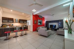 a kitchen and a living room with red walls at 3035 - Chantico 202 in Santa Cruz Huatulco