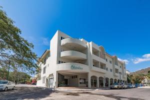a large white building with cars parked in a parking lot at 3035 - Chantico 202 in Santa Cruz Huatulco