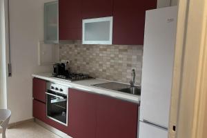 a small kitchen with red cabinets and a sink at Anna House in Cosenza