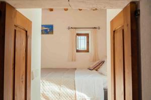 1 dormitorio con cama y ventana en Charming Ibiza villa, en Sant Llorenç de Balàfia