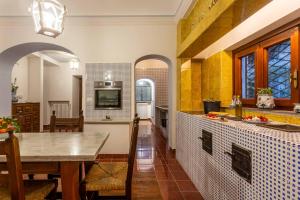 a kitchen with a table and a dining room at Villa Le Pagine Bianche in Lacco Ameno