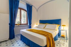 a blue and white bedroom with a bed and a window at Villa Le Pagine Bianche in Ischia