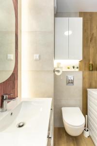 une salle de bain avec un lavabo blanc et des toilettes dans l'établissement Apartament Oscar, A4, à Lublin