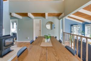 a dining room with a wooden table and a tv at Renton Home with Fire Pit and Nearby Lake Access! in Renton